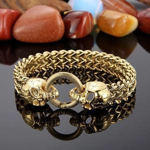 Detailed macro view of golden punk skull clasp on heavy braided stainless steel chain