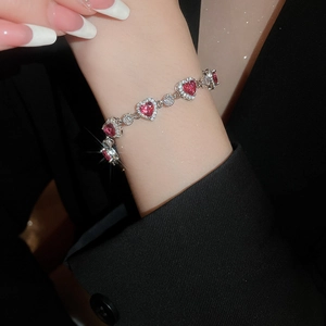 Detail of luxury heart bracelet with pink zircon gems and pavé crystals on wrist