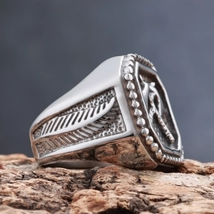 Vintage Nordischer Wikinger Axt-Ring mit gravierten Federmustern auf rustikalem Holzboden