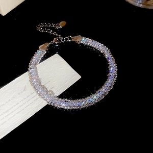 Macro detail of silver choker necklace featuring rows of sparkling round-cut crystals