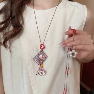 Close-up of Hello Kitty resin pendant necklace with colorful beads on a brown cord strap