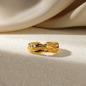 Macro shot of gold adjustable ring with irregular wave texture and molten metal finish
