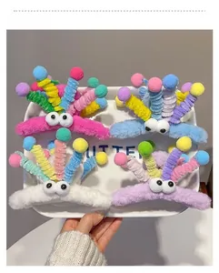 Close-up of funny plush shark hair claws with spring antennas and googly eyes in a tray