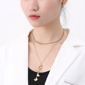 Detail of double-layer gold butterfly necklace and matching stud earrings on a model