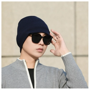 Outdoor shot showing the detailed knit texture and ear protection of a dark blue beanie