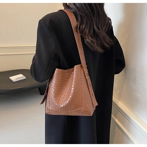 Close-up of brown crocodile texture tote bag with wide shoulder strap detail