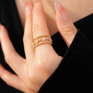 Close-up of golden double-layer open star ring with sparkling zircons on model's hand