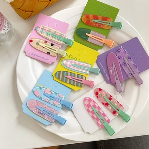 Set of colorful candy-colored hair clips with fruit and plaid patterns on duckbill clips