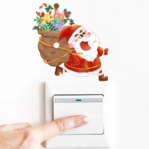 Glow-in-the-dark Santa Claus switch sticker showing scale with a hand pressing the button
