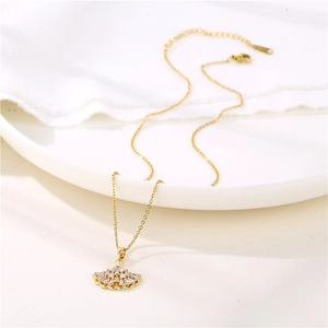 Golden fan-shaped ginkgo leaf necklace with zircon inlay on a white ceramic plate