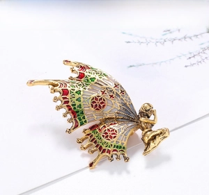 Macro detail of vintage butterfly fairy brooch with hollow enamel wings in gold alloy