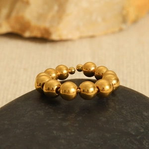 Minimalist 18K gold plated stainless steel beaded open ring on a natural stone base