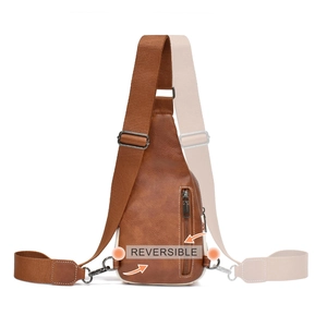 Detail showing the reversible shoulder strap feature on the brown canvas crossbody bag