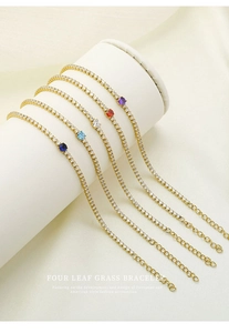 Detail view of five gold-plated tennis bracelets with colorful gemstone centers