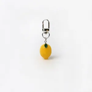 Macro detail of handmade lemon resin pendant with green leaves and silver metal buckle