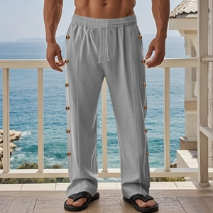 Detail of light grey linen trousers with amber side buttons and a drawstring waist