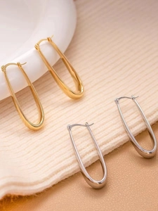 U-shaped drop earrings in gold and silver finishes on textured fabric