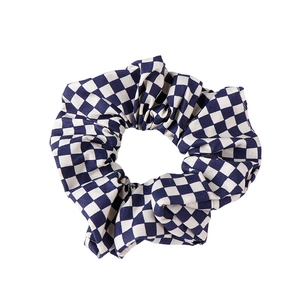 Navy blue and white checkerboard scrunchie made of pleated fabric for hair styling