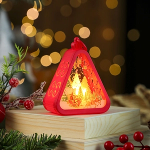 Close-up of red triangular LED lantern with Santa Claus sleigh design on a wooden base