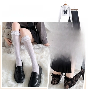 Detailansicht weißer Socken mit Herzmuster und schwarzer Overknee-Socken aus floraler Spitze