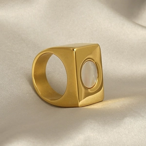 Detail of 18k gold geometric signet ring with mother of pearl inlay on silk fabric