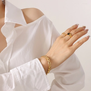 Modernes goldenes Titanstahl-Armband und Smile-Ring-Set auf der Hand des Modells