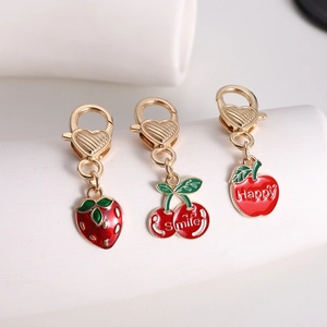 Detail of creative cherry, strawberry and apple enamel charms with heart lobster clasps