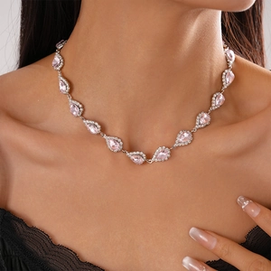 Close-up of pink teardrop crystal pendant with zircon halo on silver chain for women