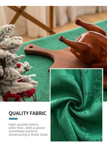 Detail of green Christmas tablecloth with subtle snowflake texture and satin finish