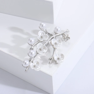 Detail shot of plum blossom shell brooch with pearls on a silver branch pin