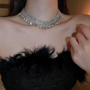 Gros plan du collier choker argenté avec franges en strass et pendentif carré