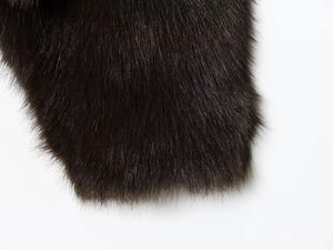 Détail macro de la texture de fourrure synthétique marron foncé au fini brillant luxueux