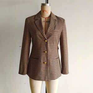 Detail of classic houndstooth blazer featuring three gold buttons and notch lapels