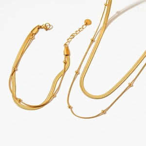 Macro view of gold-plated double-layer snake and bead chain necklace and bracelet set