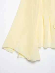 Vue détaillée du tissu en mousseline jaune clair avec coutures fines d'ourlet roulé