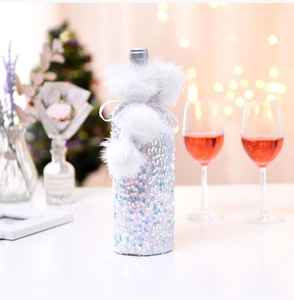 Detail of Christmas wine bottle cover with white sequins, plush trim and festive ribbon