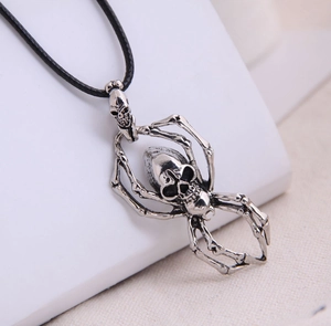 Detailed close-up of a vintage skull spider pendant on a black cord necklace