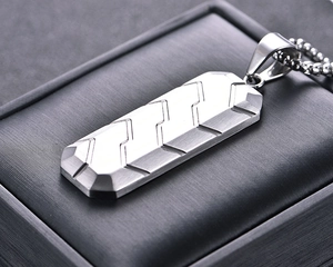 Macro shot of silver hexagon pendant with tire texture on dark display box