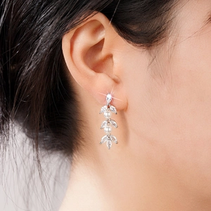 Detail van luxe kwastjes oorbellen met marquise zirkoon en parels op een model