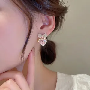 Elegance pink heart drop earrings with pearl bow and gold plating on female model