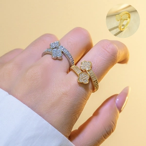Macro detail of gold and silver four-leaf clover open rings with pavé crystal settings