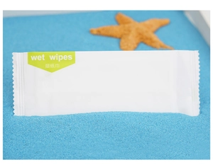Single packed individual wet wipe on blue sand with a starfish for marine theme