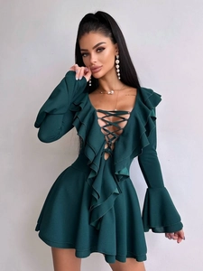 Détail de la robe vert foncé avec décolleté en V à lacets et bordures volantées élégantes