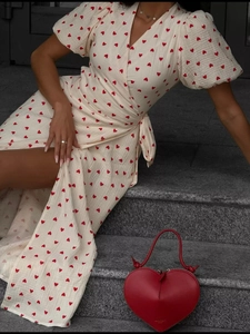 Detail of V-neck wrap dress with red heart print, puff sleeves and waist tie detail