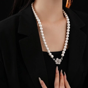 Elegant pearl necklace with zircon flower pendant worn on black blazer for premium style