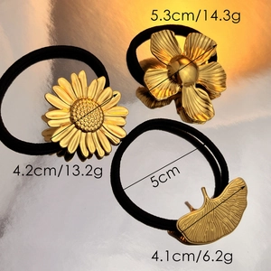 Golden floral hair ties set featuring daisy and ginkgo leaf designs on black bands
