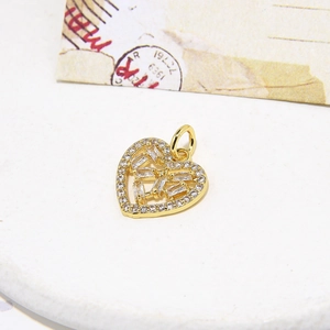 Fashionable gold heart pendant necklace with shimmering zircon stones on textured white surface