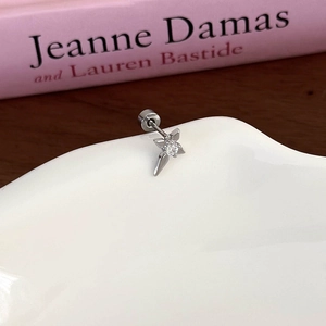 Detailed view of silver star stud earring with zircon on a ceramic plate edge