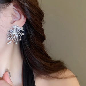 Detail view of radiant firework star pearl earring on ear with silver finish and crystals