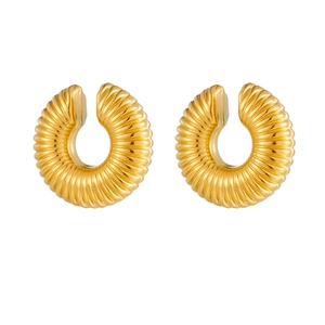 Macro view of gold chunky C-shaped hoop earrings with detailed ribbed texture details